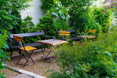 Turuncu sandalyeleri ve güzel çiçekleri olan büyüleyici bir bahçe.  