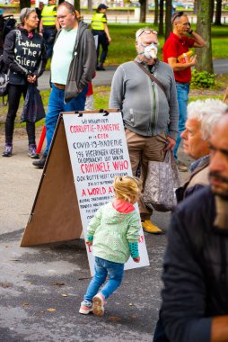 Lahey, Hollanda 04 Eylül 2020 'de, Covid-19' un yayılmasının WHO 'nun yolsuzluk ve suç eylemlerinin sonucu olduğu yönündeki endişelerini dile getiren pankartlarla protestocular 