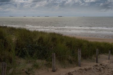 Dunes on the  Katwijk beach, Netherlands, with cruisers and tankers on the horizon clipart