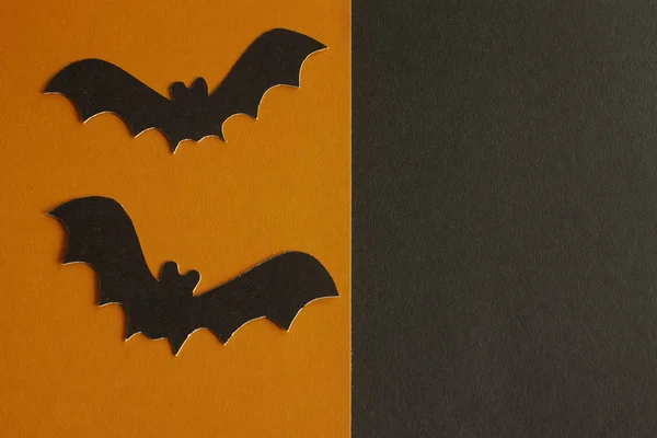 bats made of paper on orange-black background