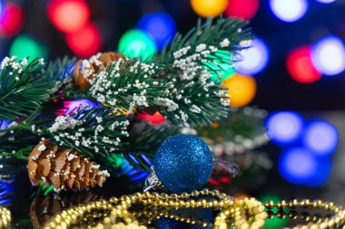 bir yumru ve güzel bir yansıması ve renkli noktalar arka planda siyah bir masada Noel ağacının dalını