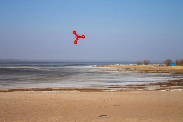 toy red boomerang flying in the air against the blue sky.sports and active games