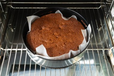 bir metal ızgara üzerinde bir elektrikli fırında pişirme için siyah taze pişmiş kek