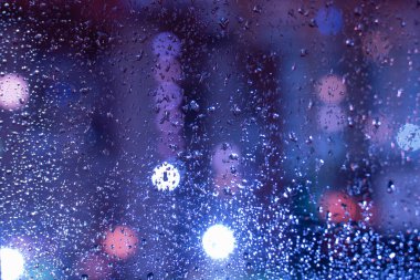 güzel bir bulanık arka plan ile cam yağmur damlaları