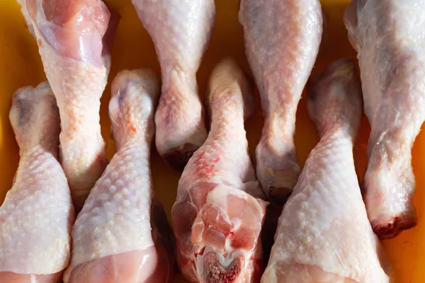 Arka plan olarak bir satır closeup taze et tavuk bacakları — Stok fotoğraf