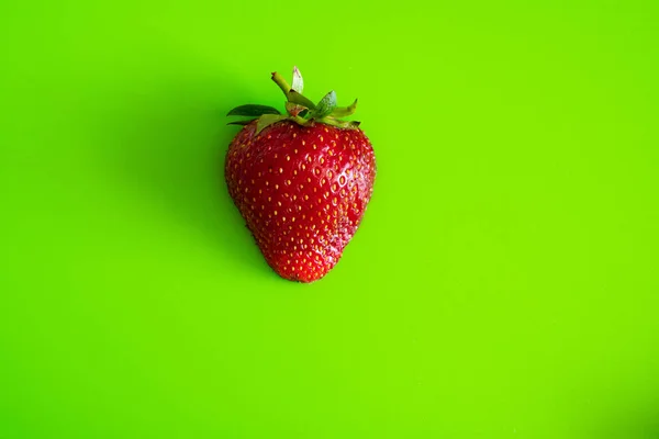 Красная спелая ягода клубники на зеленом фоне Мэтта — стоковое фото
