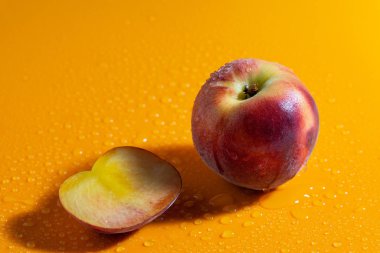 sulu taze olgun şeftali su damlaları ile turuncu mat arka plan üzerinde. meyve ve sağlıklı gıda