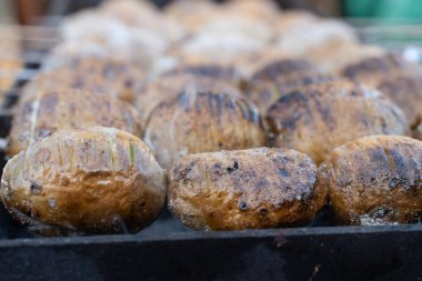 Altın bir kabuk ile ızgara üzerinde kömürler üzerinde pişmiş patates. gıda hazırlama