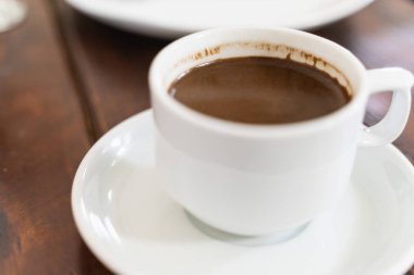 seçici odak ve son derece bulanık arka plan ile ahşap masa üzerinde beyaz kahve Fincan