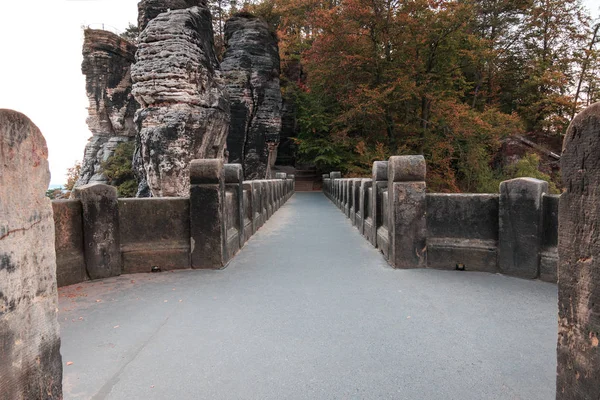 Upper course and footpath above the Bastei bridge in the Saxon Switzerland National Park Elbe Sandstone Mountains. Fortress and historic stonework with rock formations and trees in autumn.