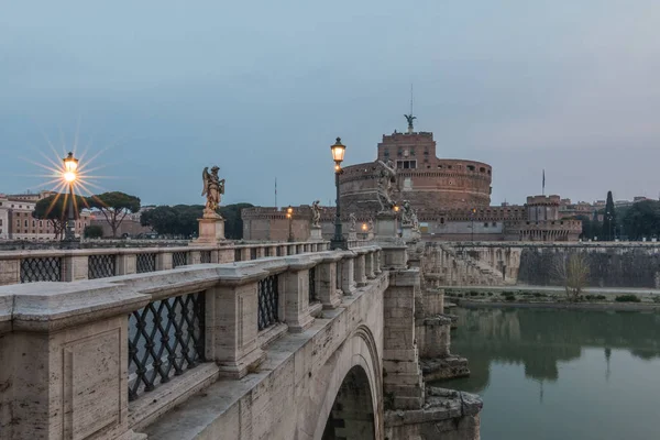 Şafakta Tiber üzerinde tarihi aydınlatma ile Yanal görünümü Taş köprü. Roma'nın tarihi merkezinin merkezinde arka planda Castle Sant Angelo ile Aurelius köprü