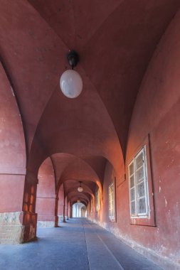 Kahverengi bir kemerin geçişi. Hradcany meydanında Prag'da tavanlarda ev ve lambalar. Duvardaki tarihi pencereler. Zeminde granit taşlar ve duvarlarda kaide