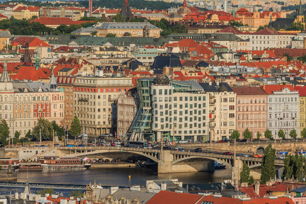 View on historic buildings of Pragues Mala Strana district with the river Vltava and the streets, the bridge, ships on the shore in sunny day and blue sky