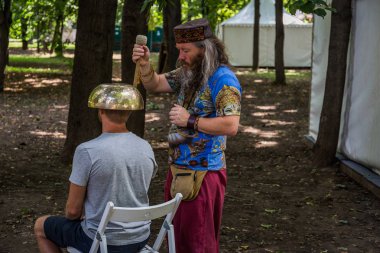 Moskova, Park Krasnaya Presnya, 05 Ağustos 2018: bir büyük Tibet singing kase ile masaj yapan bir adam
