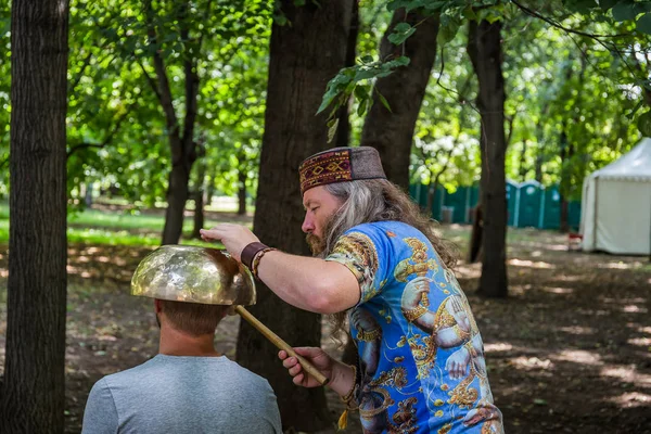 Moskova, Park Krasnaya Presnya, 05 Ağustos 2018: bir büyük Tibet singing kase ile masaj yapan bir adam