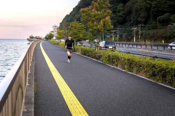 日本运动员沿着海滨奔跑 — 图库照片