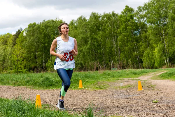 Een volwassen vrouw is bezig met rennen in de natuur — Stockfoto