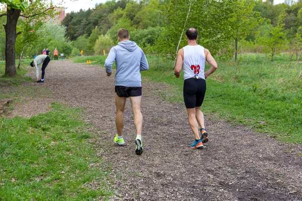 Paar-twee volwassen mannen zijn bezig met hardlopen in de natuur. Achteraanzicht. — Stockfoto