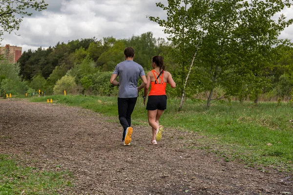 Een paar - jonge man en vrouw joggen in de natuur - achteraanzicht — Stockfoto