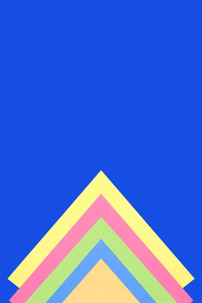 Mavi arka planda çok renkli üçgenler. Minimalist tarzda. Boşluğu kopyala.