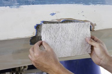 Bir işçi bir tekne onarmak için bir Fiberglas levha ölçme