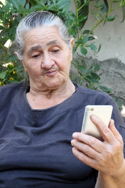 Yaşlı kadın Smartphone'da merakla arıyor