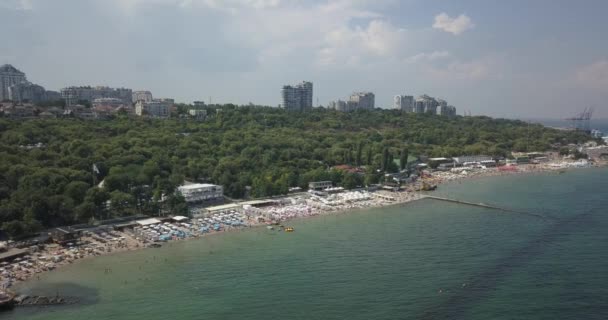 Воздушный. Популярный городской пляж. На побережье много солнечных зонтиков. 4К. Одесса, Украина — стоковое видео