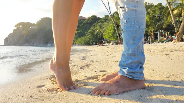 美しい夕日時のビーチで海の近く日付の間に愛のカップルの足 少女は愛する人にキスをする彼女の指先に起きる — ストック写真