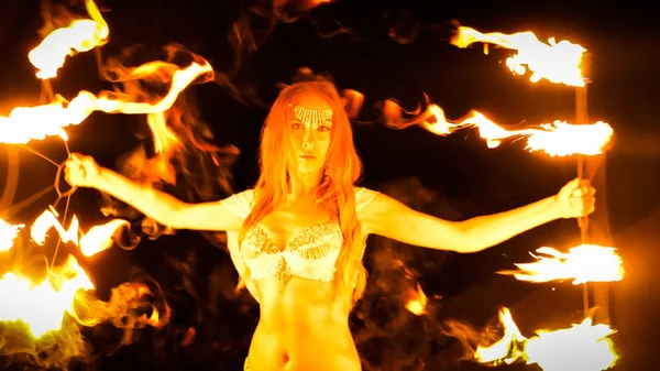 Fire woman dancing with burning fans