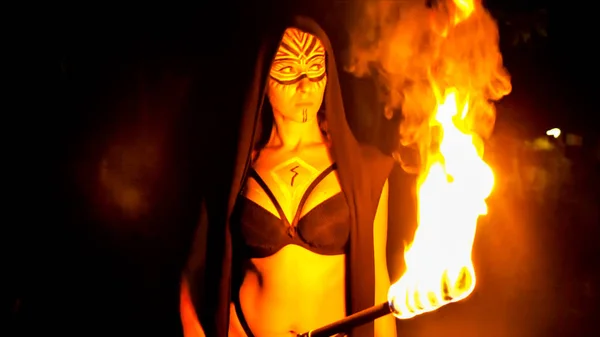脸上涂满油彩的女人拿着火把摆姿势 — 图库照片