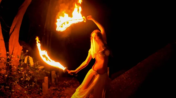 火女人摆姿势与燃烧的一对剑 — 图库照片