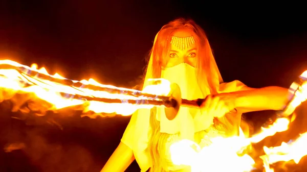 火女人摆姿势与燃烧的一对剑 — 图库照片