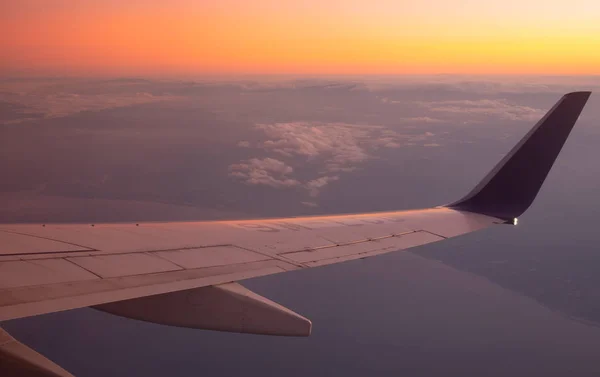 雲の上の日没時間 空に翼の航空機 — ストック写真