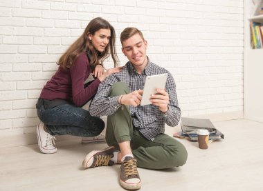 Adam ve kız öğrenciler yere oturmak