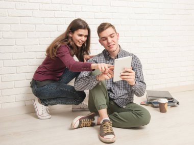 Adam ve kız öğrenciler yere oturmak