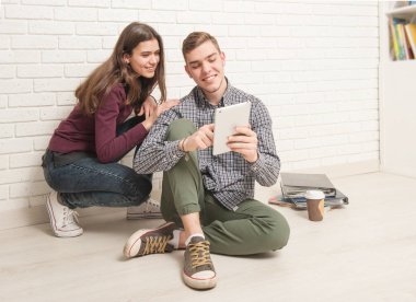 Adam ve kız öğrenciler yere oturmak