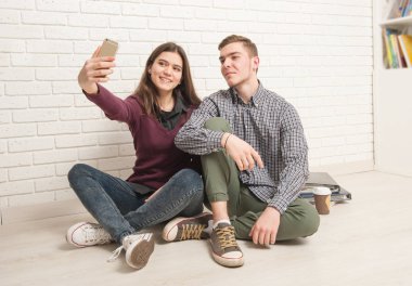 Adam ve kız öğrenciler yere oturmak