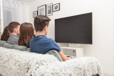 Gençler kanepede oturan ve Tv izlerken