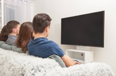 Gençler kanepede oturan ve Tv izlerken