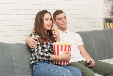 İki Genç Tv izlerken kanepede oturuyor