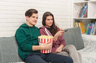 İki Genç Tv izlerken kanepede oturuyor