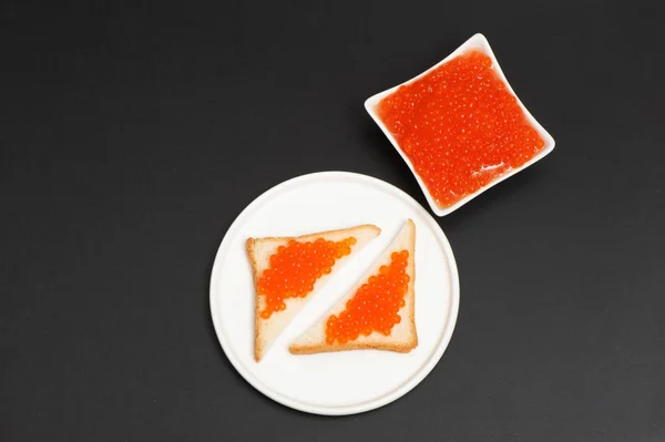 Caviar vermelho e partes de pão em uma chapa — Fotografia de Stock
