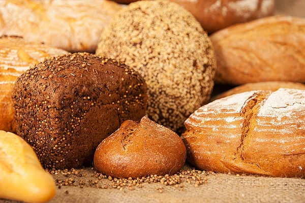 Varios tipos de pan sobre fondo de arpillera —  Fotos de Stock