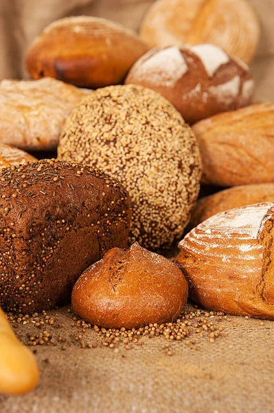 Vários tipos de pão no fundo da serapilheira — Fotografia de Stock