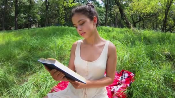 Fille lit un livre sur un plaid