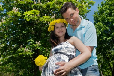 Çayırda hamile bir karısı olan bir adam.