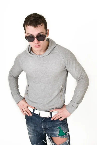 Hombre joven con una sudadera gris sobre un fondo blanco —  Fotos de Stock