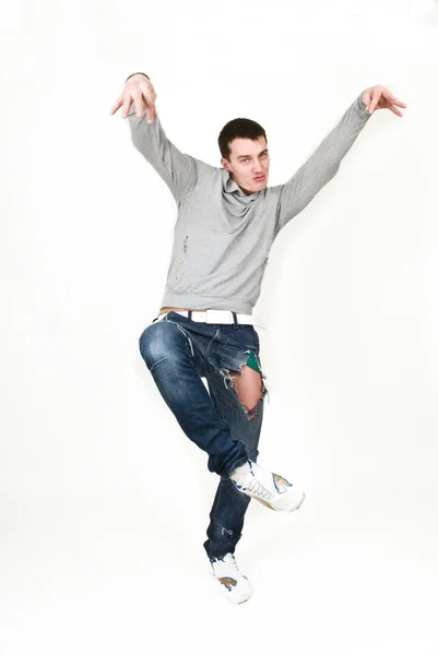Молодий чоловік танцює в сірому светрі на білому тлі — стокове фото