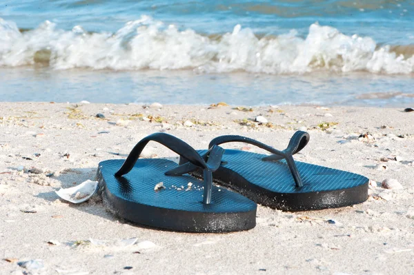 Schwarze Flip Flops an der Küste — Stockfoto