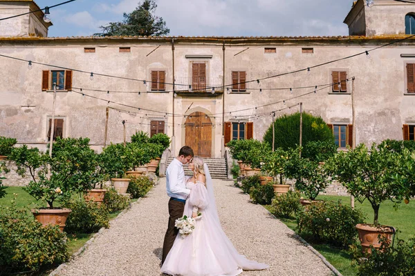 Весілля у Флоренції, Італія, в старому вілла-виноробстві. Весільна пара ходить в саду. Любляча наречена і наречений. — стокове фото